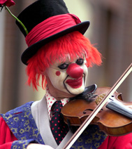 Durant le spectacle, le clown joue du violon : les enfants adorent